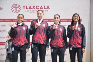 El equipo de relevos 4x100 Femenil de Quintana Roo en el podio tras recibir su medalla de bronce.