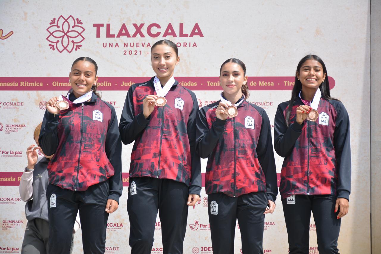 El equipo de relevos 4x100 Femenil de Quintana Roo en el podio tras recibir su medalla de bronce.