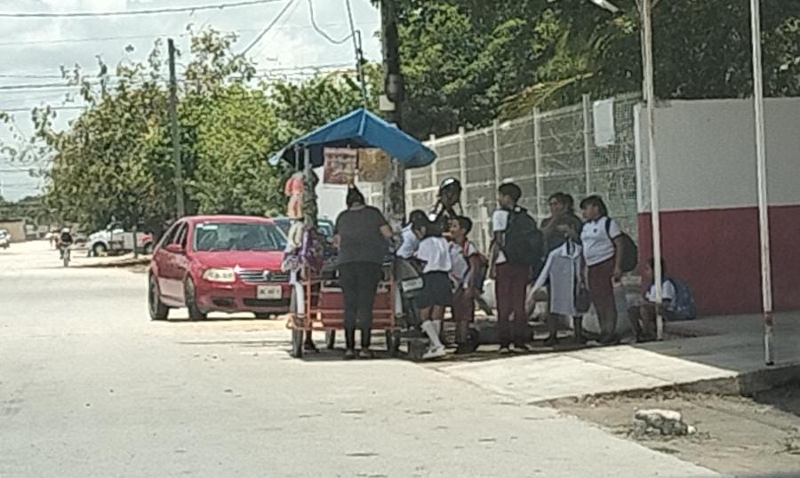 La venta de comida chatarra persiste en las afueras de escuelas en Cancún.