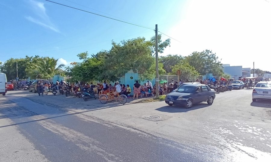 Cientos de personas forman una larga fila afuera de la escuela “Centenario de la Revolución” en Chetumal para registrarse en el programa de vivienda.