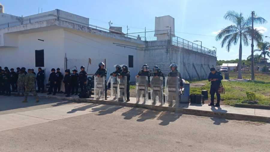 Un interno muestra un trozo de madera de un mueble roto durante la protesta.