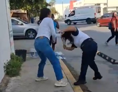 Una mujer agrediendo a una guardia de seguridad, un reflejo de la violencia de ambulantes en Playa del Carmen.
