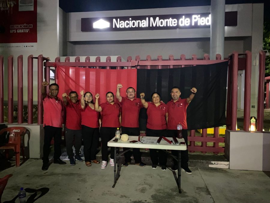 Trabajadores del Nacional Monte de Piedad en Chetumal colocan las banderas de huelga.