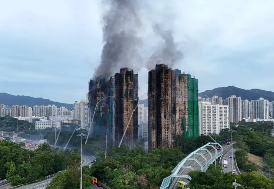 Columnas de humo y llamas trepan por los andamios de bambú en el complejo Wang Fuk Court.