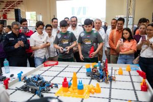 Jóvenes competidores de robótica armando sus proyectos en el Poliforum de Playa del Carmen.