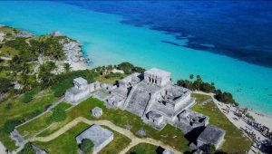 Visitantes disfrutan de las estructuras mayas en la Zona Arqueológica de Tulum.