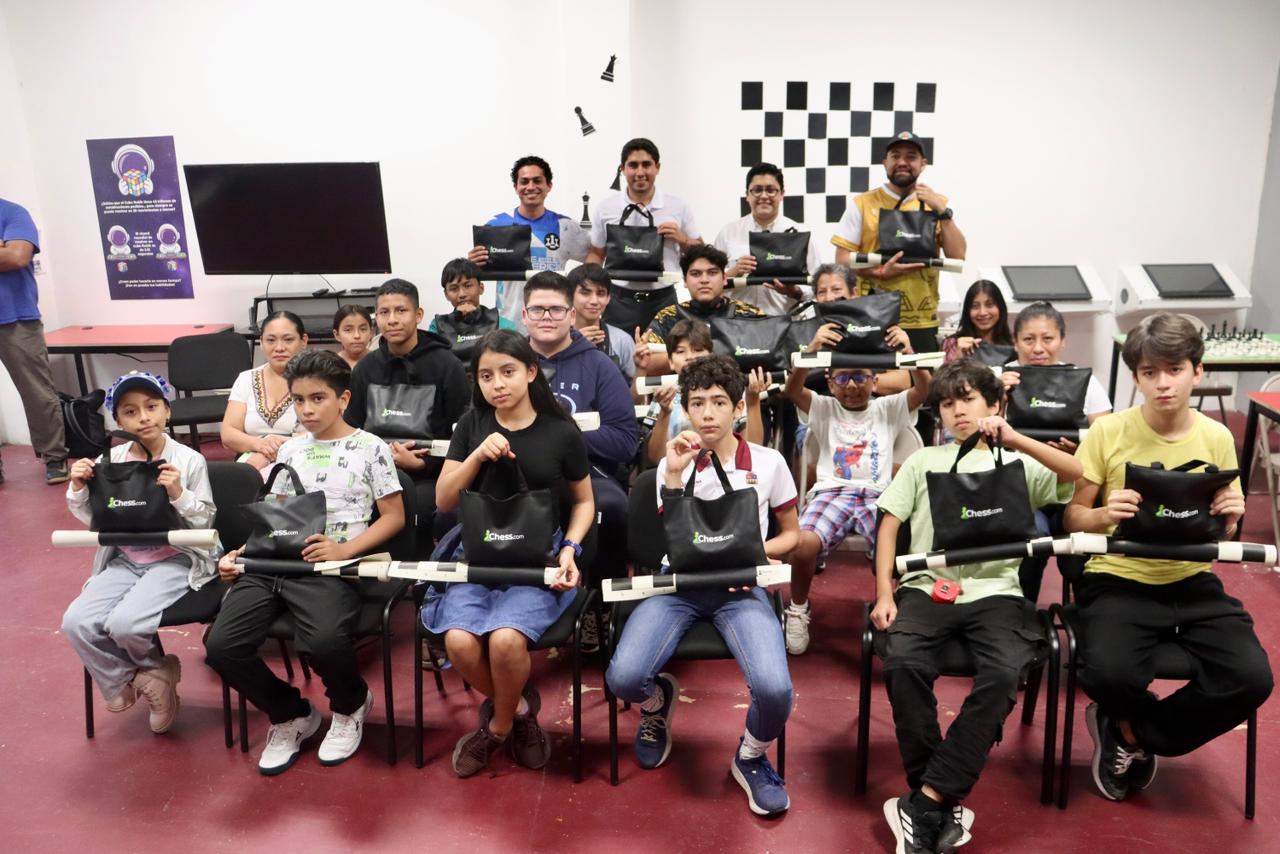 Jacobo Arzate Hop y Cristopher Malpica Morales entregan tableros de ajedrez en Quintana Roo a jóvenes integrantes del Club Torre Homérica Sayab.