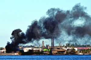 Equipos de emergencia trabajan para sofocar el incendio registrado en los almacenes de la refinería del puerto de La Habana.