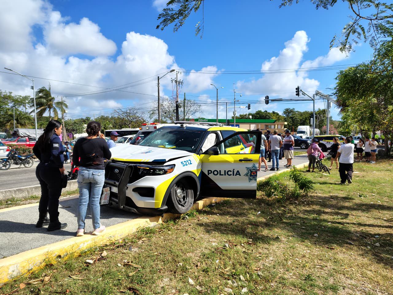 Paramédicos brindan los primeros auxilios al motociclista lesionado tras el impacto con la unidad policial en Cancún.