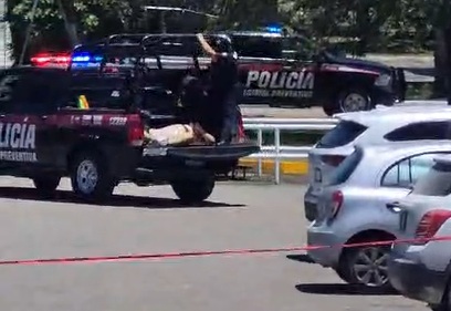 Elementos de la Policía Estatal acordonan el estacionamiento de Walmart tras el ataque armado registrado la tarde de este sábado.