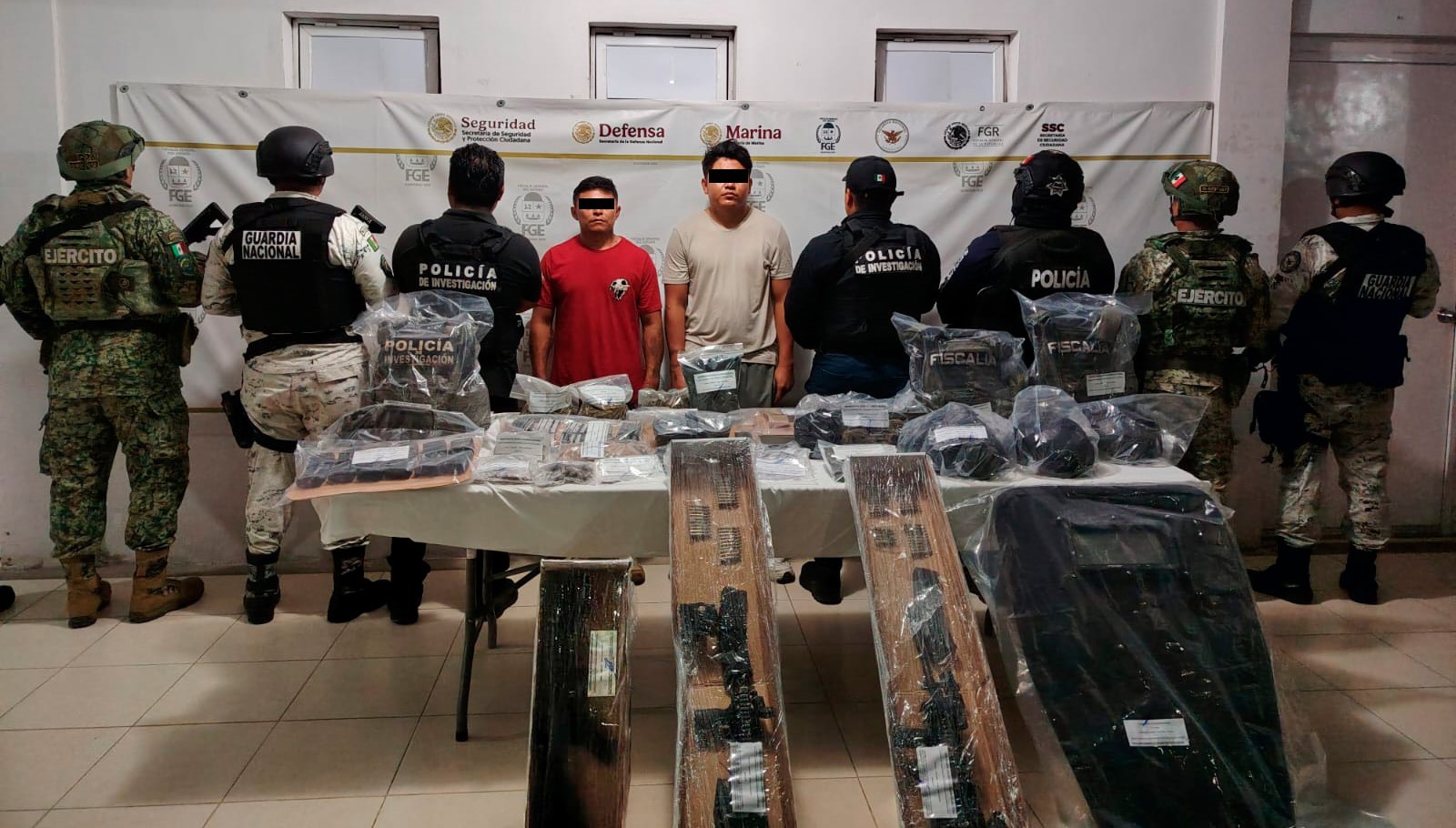 Las autoridades aseguraron armas largas y equipo táctico con logotipos de corporaciones policiales durante la detención.