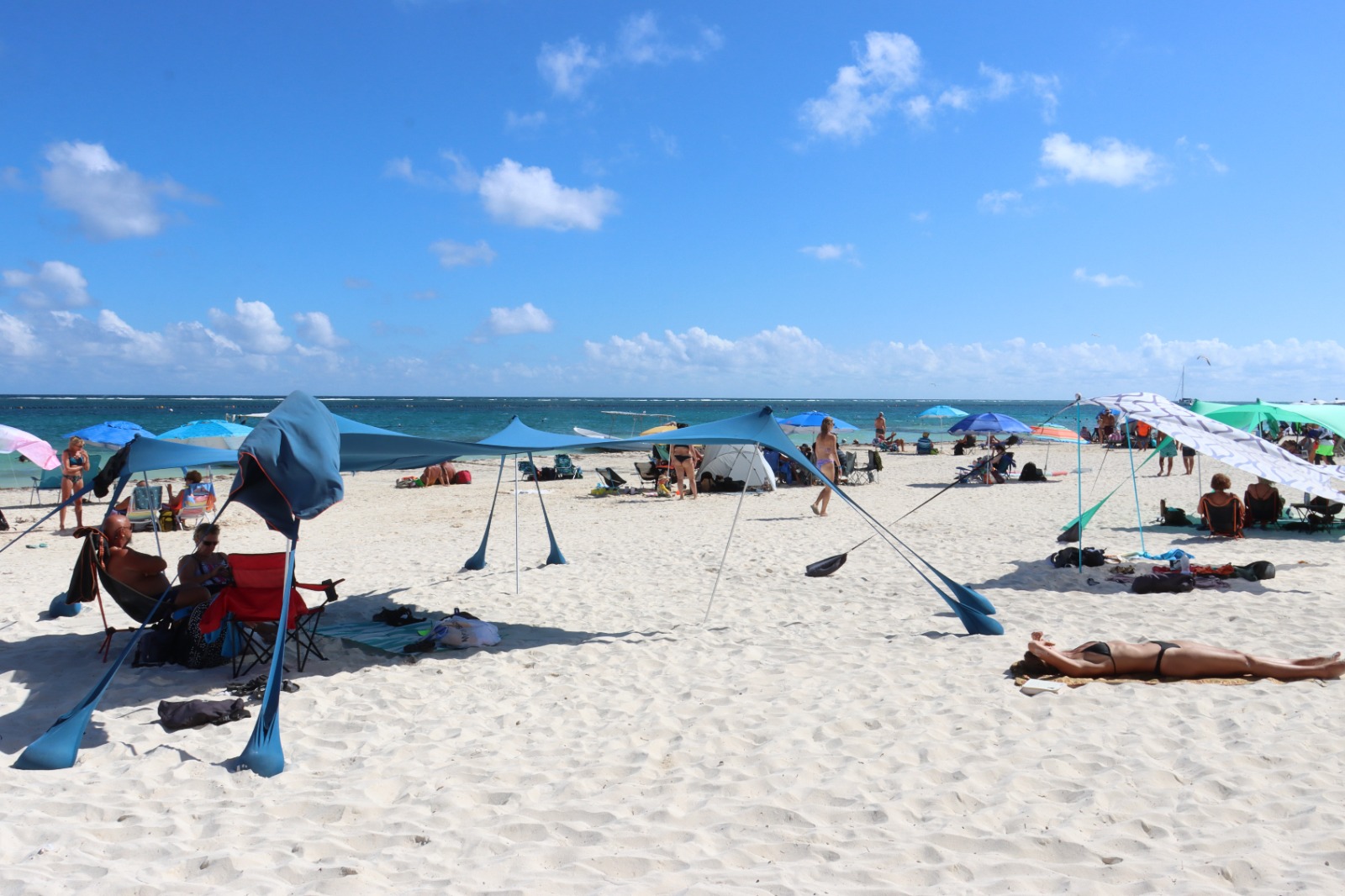 Turistas disfrutan de las aguas cristalinas y el clima soleado en las playas públicas de Puerto Morelos este domingo.