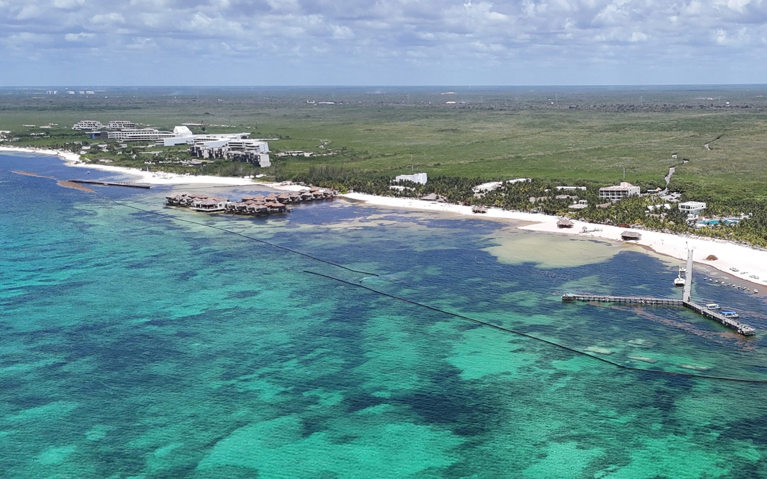 La nueva barrera privada se extiende sobre las aguas turquesa de Maroma para contener los arribos de la macroalga.