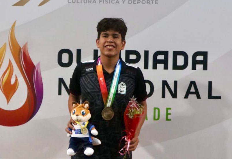 Iker Galindo García celebra su medalla de oro tras dominar la prueba de mil 500 metros libres para Quintana Roo.