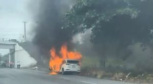 Los elementos de bomberos arrojan ráfagas de agua para extinguir el fuego concentrado en el motor del automóvil compacto.