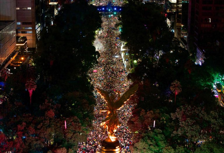 Una multitud vestida con camisetas verdes satura los alrededores del Ángel de la Independencia durante la celebración nocturna.