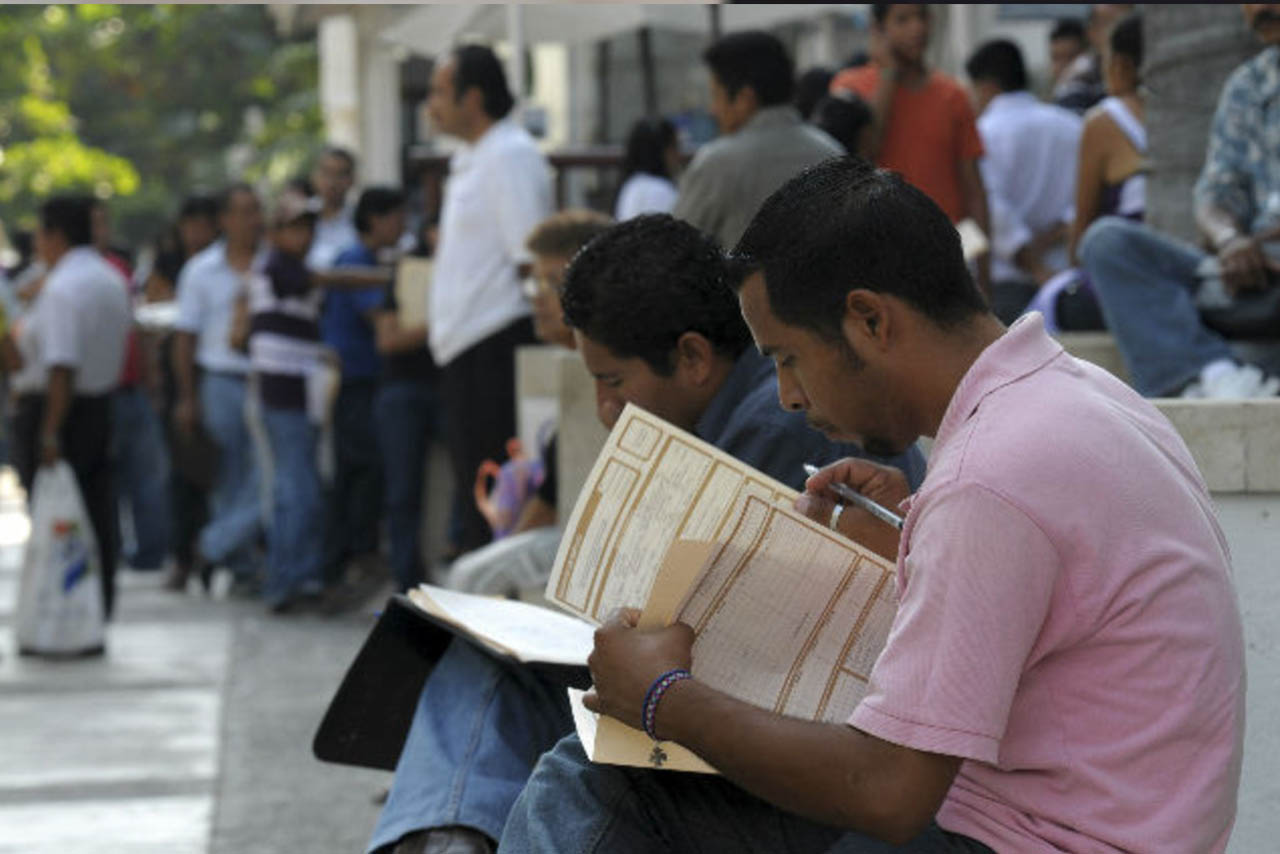 Diversas personas revisan las ofertas de trabajo publicadas en un módulo de atención ciudadana en el centro del país.