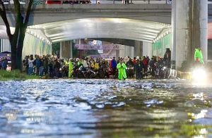 Decenas de usuarios del Tren Ligero caminan sobre las banquetas inundadas tras la suspensión del servicio en la estación Huipulco.