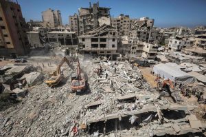 Equipos de rescate y vecinos trabajan con medios rudimentarios entre los escombros del edificio colapsado.
